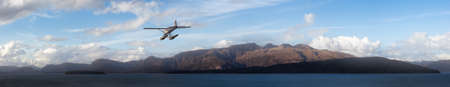 Seaplane Aircraft Flying over the Pacific Ocean Coast. Cloudy morning Colorful Sky. 3d Rendering Adventure Dream Concept Artwork. Background Nature Image from Glacier Bay National Park, Alaska.の写真素材