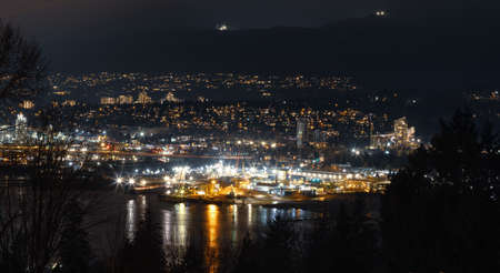 Modern Cityscape at Night with buildings and mountain in background. Taken from Capitol Hill in Burnaby, Vancouver, British Columbia, Canada.の写真素材