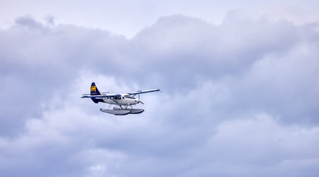 Downtown Vancouver, British Columbia, Canada - May 7, 2022: Harbour Air Seaplane arriving to Coal Harbour. Cloudy Sky Background.のeditorial素材