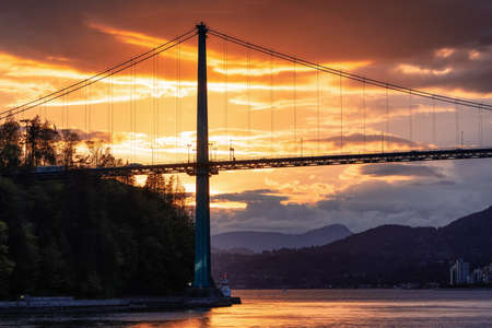 Stanley Park, Lions Gate Bridge and City with Mountains in Background on the West Coast of Pacific Ocean. Dramatic Sunset. Vancouver, British Columbia, Canada.の写真素材