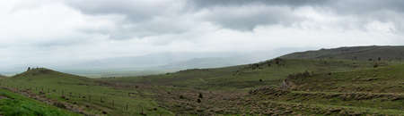 Green Field with American Mountain Landscape. Cloudy Rainy Day. Montana, United States of America. Nature Background Panoramaの写真素材