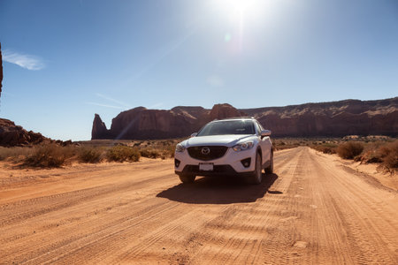 Oljato-Monument Valley, Utah, United States - June 6, 2022: Mazda CX-5 Riding on a Scenic Road in the Dry Desert with Red Rocky Mountains in Background.のeditorial素材