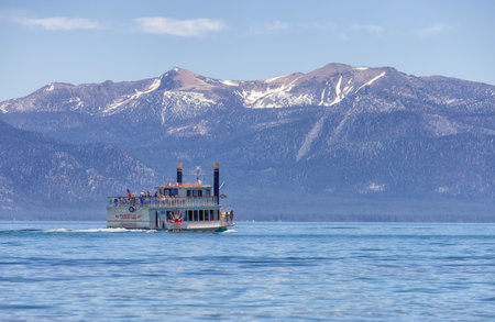 Lake Tahoe, California, United States of America - June 10, 2022: Sternwheeler with tourists on a lake with mountain landscape in background.のeditorial素材