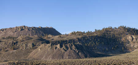 Dry rocky desert mountain landscape with trees. Sunny Morning Sky. California, United States of...