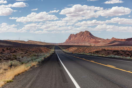 Scenic Road in the Dry Desert with Red Rocky Mountains in Background. Near Page, Arizona, United...