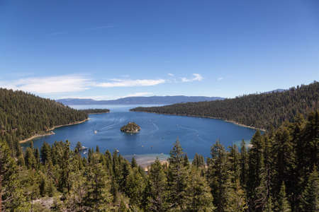 View of Large Bay and Lake with Boats, Small Island, Trees and Mountains. Summer Season. Emerald...