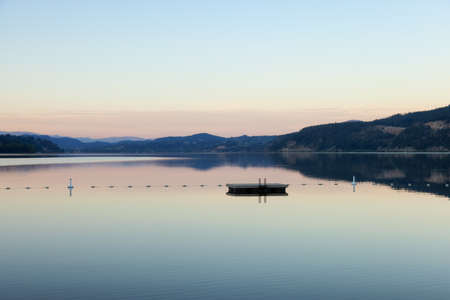Peaceful View of Wood Lake with Reflection on the water and mountains in background. Lake Country, Okanagan, British Columbia, Canada. Sunriseの写真素材