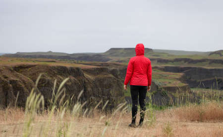 Woman Hiker at American Nature Landscape during cloudy day. Palouse Falls State Park, Washington, United States of America. Nature Backgroundの写真素材