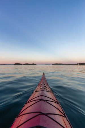 Sea Kayak paddling in the Pacific Ocean. Colorful Sunset Sky. Taken near Victoria, Vancouver Islands, British Columbia, Canada. Concept: Sport, Adventureの写真素材