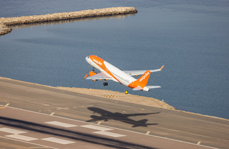 Gibraltar, United Kingdom - October 25, 2022: EasyJet Airplane taking off from the airport during sunny morning. Aerial View from Rock of Gibraltar.のeditorial素材