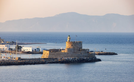 Lighthouse on the Mediterranean Sea in Rhodes, Greece. Sunny Evening.の写真素材
