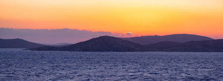 Rocky Island on Mediterranean Sea. Rinia near Mikonos, Greece, Europe. Nature Background. Sunrise Skyの写真素材