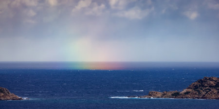 Rocky Coast and Sea with colorful Rainbow in Sky. Sardinia, Italy. Nature Background.