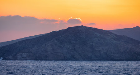 Rocky Island on Mediterranean Sea. Rinia near Mikonos, Greece, Europe. Nature Background. Sunrise Skyの写真素材