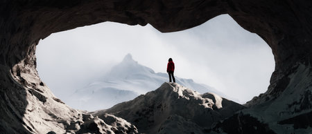 Adventurous Woman standing in a rocky cave with snowy mountains in background. 3d Rendering Artwork. Adventure Conceptの写真素材