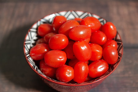 Fresh Bowl of Tomatoes on a wooden table.の写真素材