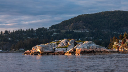 Rocky Island with Mountain Landscape in Background. Dramatic Sunset. Horseshoe Bay, West Vancouver, British Columbia, Canada.の写真素材