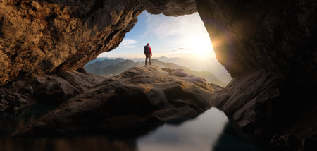 Adventurous Man Standing in cave on top of Mountain. Extreme Adventure Composite. 3d Rendering Peak. Background Aerial Image from British Columbia, Canada.の写真素材