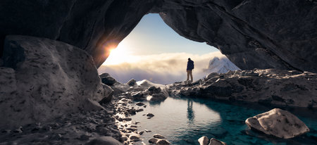 Adventurous Man Standing in cave on top of Mountain. Extreme Adventure Composite. 3d Rendering Peak. Background Aerial Image from British Columbia, Canada.の写真素材
