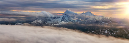 Rocky Mountain Peak covered in clouds. Aerial Landscape Nature Background. View from Airplane, Washington, USA.の写真素材