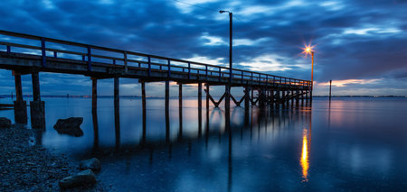 Wooden Quay at Rocky shore on Pacific Ocean West Coast. Sunset. White Rock, Vancouver, BC, Canada.の写真素材