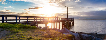 Wooden Quay at Rocky shore on Pacific Ocean West Coast. Sunset. White Rock, Vancouver, BC, Canada.の写真素材
