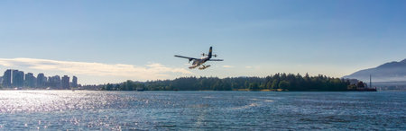 Downtown Vancouver, BC, Canada - July 18, 2017: Seaplane landing in Vancouver Harbour during sunny...