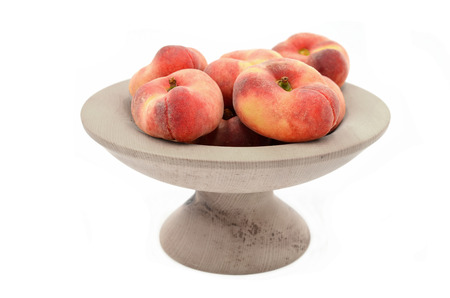 peach in bowl on white background close upの写真素材