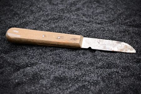 Knife on black sand close up photoの写真素材