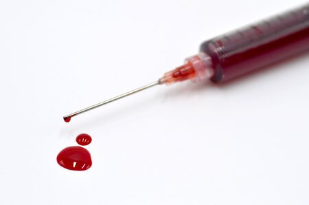 Syringe with blood white background close up photoの写真素材