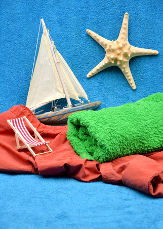 deck chair green towel starfish and boat close up photoの写真素材