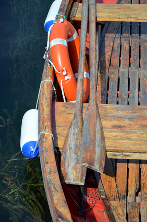 boat rescue tire and paddle in color red close up photoの写真素材