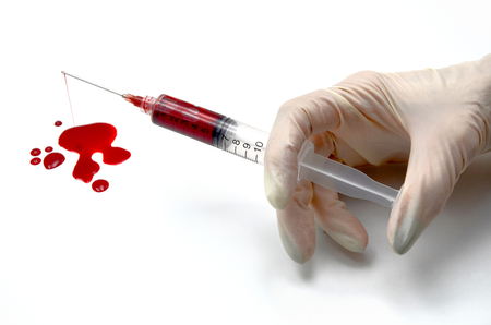 hand and injection of blood on white backgroundの写真素材