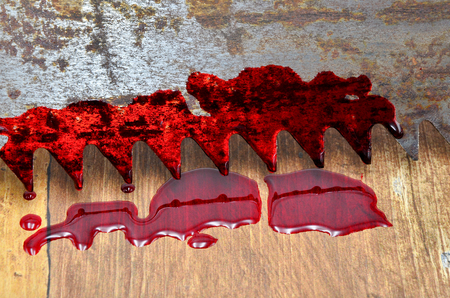 saw with blood on a wood close upの写真素材