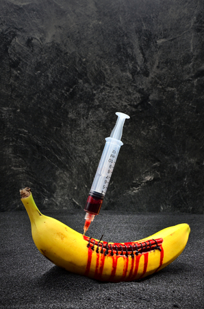 banana with a syringe on a dark backgroundの写真素材