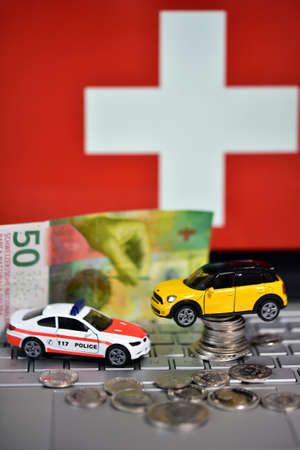 Switzerland flag and toy car on coins. Financial crisis concept.の写真素材