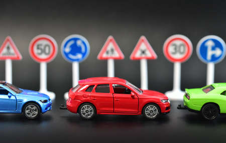 Miniature car and traffic signs on black background. 3d renderingの写真素材