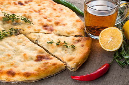 Top view of calzone pizza or chicken mushroom pie with pepper, lemon, rosemary and teaの写真素材