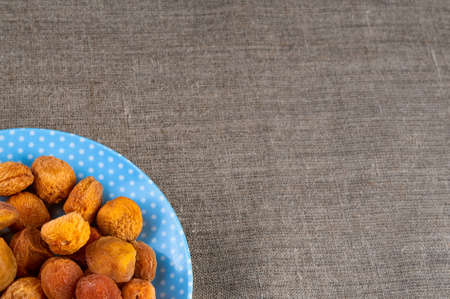 Heap of dried apricots on hessian linen clothの写真素材