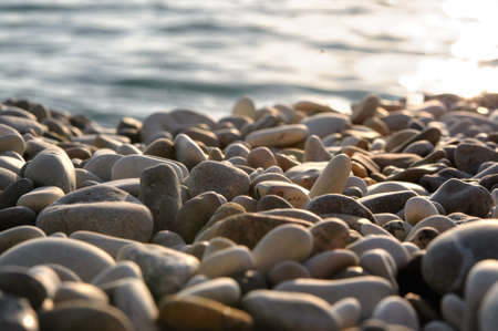 Sea gravel shore or beach with sea water at sunset with nobodyの写真素材