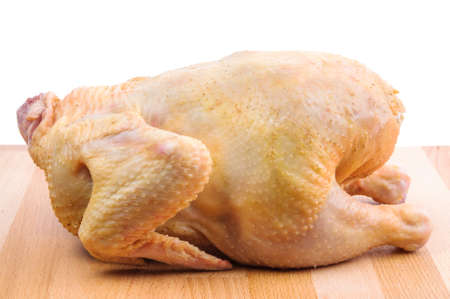 Raw chicken on wooden cutting board isolated on white backgroundの写真素材