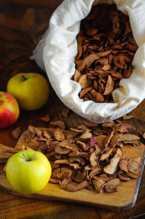Dried apples and bag on wooden table