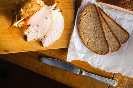 Delicious roast turkey meat with with bread sclices on old cutting board, Vintage country table