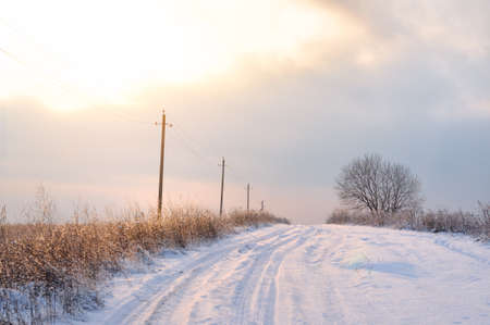 Beautiful foggy winter landscape with road at sunsetの写真素材