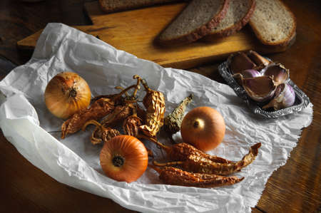 Onion, garlic and dried pepper on old paper, Vintage country tableの写真素材