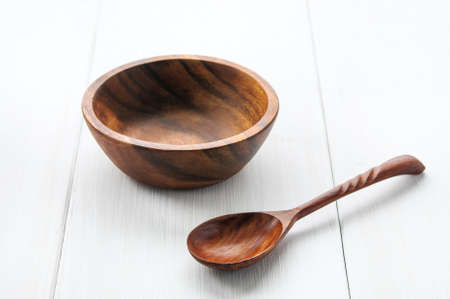 Wooden empty bowl and spoon on white backgroundの写真素材