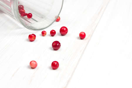 Cranberries in wooden bowl on white surfaceの写真素材