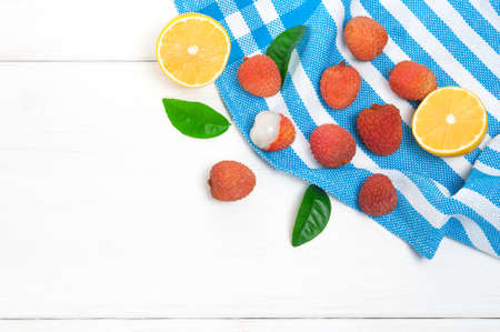 Top view: lychee fruits and lemon half on white wooden bakcgroundの写真素材