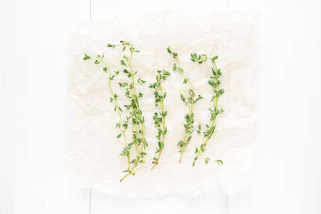 Dried thyme on baker paper on white background. Top viewの写真素材
