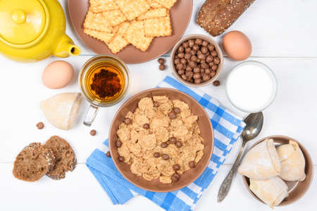 Top view of healthy breakfast for kids. Oat cereal granola in bowl on white wooden backgroundの写真素材